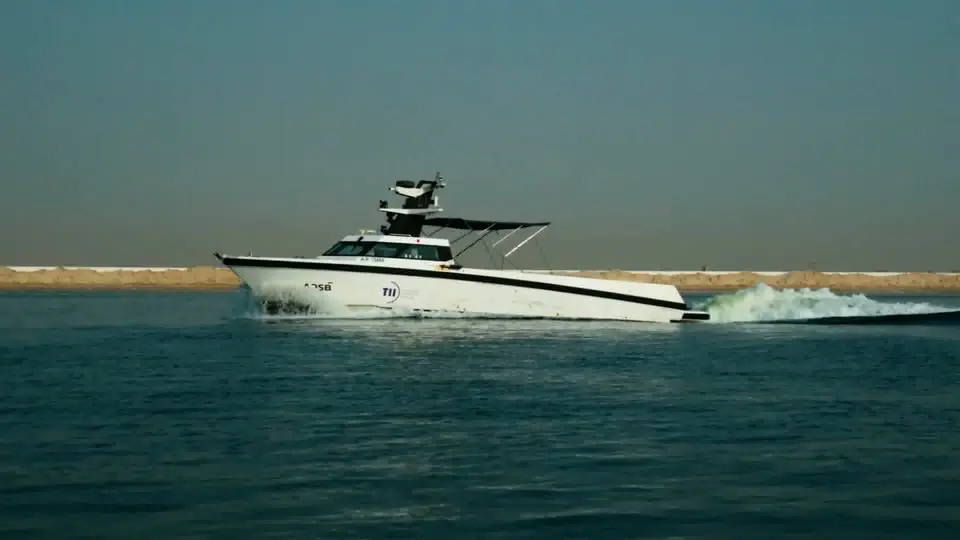The 17-metre Detector USV running at speed along the coast, its waterjet wake building behind it.