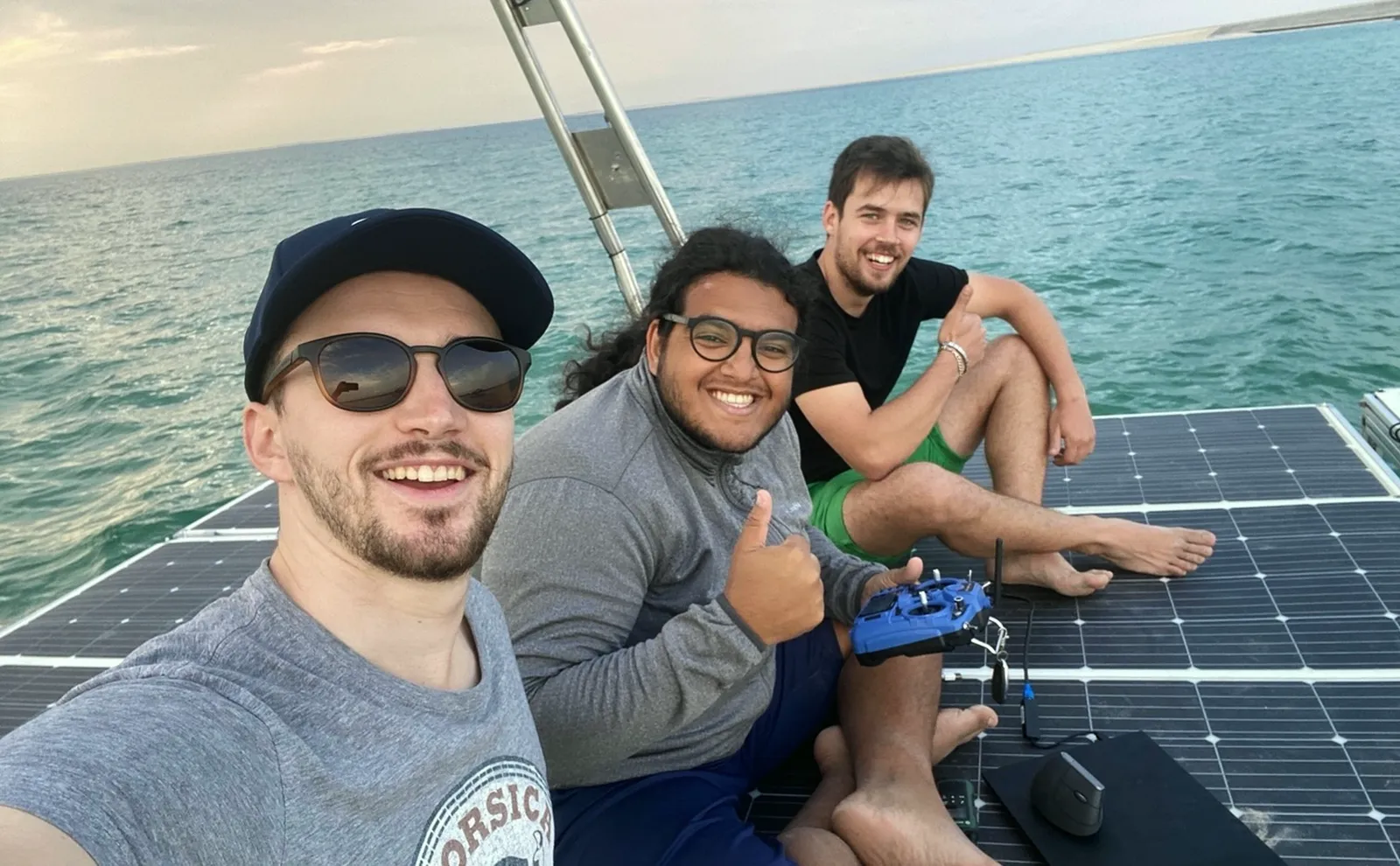 Jules and two colleagues sitting on the roof of the first USV the team built, a remotely piloted boat.
